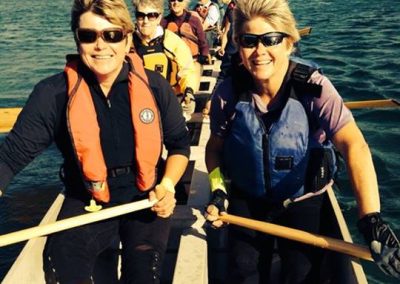 Paddlers in life jackets seated in the dragon boat